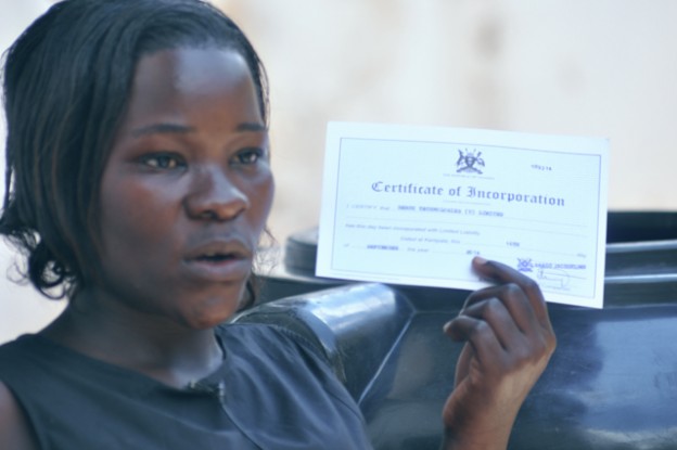 Nansamba Resty the Y2Y beneficiary showing her company registration certificate after the training & Internship program.
